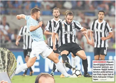  ?? — Gambar AFP ?? AKSI HAMBAR: Higuain (kanan)gagal melepasi kawalan pemain pertahanan Napoli ketika beraksi pada perlawanan Piala Super Itali di Rom, Itali pada 13 Ogos lepas.