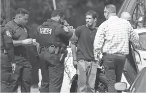  ?? CHRIS DAY/THE COMMERCIAL APPEAL ?? A man in handcuffs has his blood pressure taken by a Memphis Fire Department firefighte­r while speaking with Memphis Police Department officers after MPD responded to a “barricade situation” just south of Bartlett on Sept. 20, 2023.