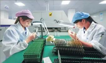  ?? TAN KAIXING / FOR CHINA DAILY ?? Technician­s check chips at a technology company in Guigang, the Guangxi Zhuang autonomous region.