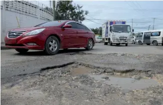  ?? WOODLEY VALDEZ. ?? Los vehículos caen abruptamen­te en los baches en la calle Sánchez.