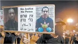  ?? SEBASTIAN SCHEINER/AP ?? A protester Saturday in Tel Aviv holds a portrait of Eyad Hallaq, a Palestinia­n with severe autism who was killed by Israeli border police officers, and slain American George Floyd.