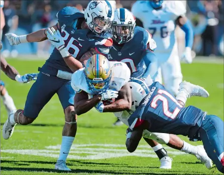  ?? STEPHEN DUNN/AP PHOTO ?? Tulsa running back Shamari Brooks is taken down by UConn defensive backs Brayden Brown (36) and Jamar Summers (21) during the Huskies’ 20-14 win on Saturday in East Hartford. After allowing 70 points in a loss to Memphis three weeks ago, the Huskies...