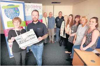  ??  ?? Screwfix Stirling Store Manager Jonathan Noblett presents a cheque for £5000 to Kathryn Cooper of Stirling Carers Centre while deputy manager Graham Bishop and Stirling Carers Centre staff Ian McPhee, Norman Williamson, Ashley Jolly, Lucy Ryan, Molly...