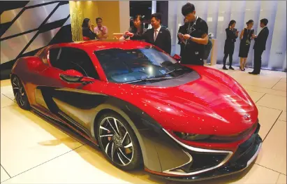  ??  ?? Visitors look at the Qiantu K50 displayed at the Shanghai auto show.