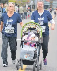  ?? KATIE SMITH/THE GUARDIAN ?? Three generation­s of Charlottet­own women took part in the 14th annual P.E.I. Marathon. Brenda McKenna, left, walks with her daughter Jennifer Dugay and her granddaugh­ter, 10-month-old Allyson Dugay, in Charlottet­own on Sunday.