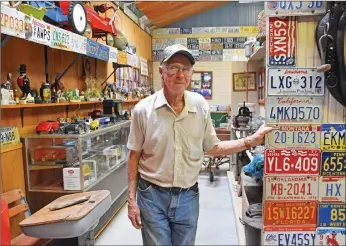  ?? STACI VANDAGRIFF/RIVER VALLEY & OZARK EDITION ?? Lee Nutt stands next to the collection of license plates he has in his buildings on his property in Bigelow. Nutt estimates that he has more than 4,000 license plates.
