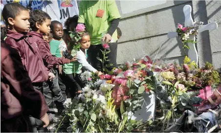  ?? PICTURE: ARMAND HOUGH ?? DEATH OF INNOCENCE: Children lay down flowers at the site where the body of Courtney Pieters of Elsies River were found after she was raped and murdered in May. They were visiting the crime scene together with community members.