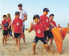  ?? Courtesy: Organisers ?? Dubai’s youngest residents do their bit to rid Umm Suqeim open beach of trash while having fun yesterday.