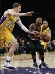  ?? ALEX GALLARDO — THE ASSOCIATED PRESS FILE ?? In this Oct. 11, 2016 photo, Portland Trail Blazers guard Damian Lillard, center, drives between Los Angeles Lakers center Timofey Mozgov (20) and guard D’Angelo Russell, right, during the first half of an NBA preseason basketball game in Los Angeles.