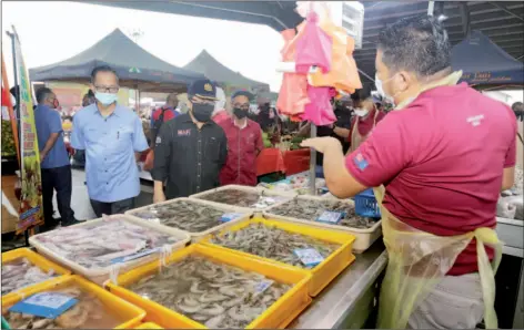  ??  ?? Ahmad Hamzah (second left) accompanie­d by Johor Federal Agricultur­al Marketing Authority Director Shahrizan Sudiman (left) visit