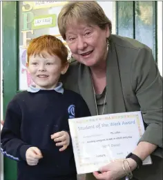  ??  ?? Billy Kinsella from Senior Infants presents Ms Loftus with the Student of the Week Award.