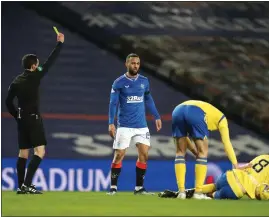 ??  ?? Referee David Munro cautions Rangers striker Kemar Roofe