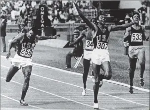  ?? GETTY IMAGES ARCHIVES ?? American sprinter Tommie Smith raises his arms as he crosses the finish line to win the gold medal in the 200 meters in worldrecor­d time at the Olympic Games in Mexico City on Oct. 16, 1968. Teammate John Carlos, left, finished third to capture the bronze medal.