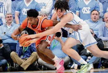  ?? ?? Chris Seward/Associated Press Syracuse guard Kyle Cuffe Jr. and North Carolina forward James Okonkwo battle for the ball during the second half on Saturday in Chapel Hill, N.C.