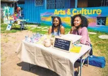  ??  ?? Bethany Wood (left) and Selena Hernandez sell homemade tea, soap and candles at the Wednesday pop-up market.