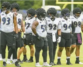  ?? KEVIN RICHARDSON/BALTIMORE ?? Ravens defensive linemen huddle up on the first day of training camp practice at the Under Armour Performanc­e Center in Owings Mills on Wednesday.
SUN