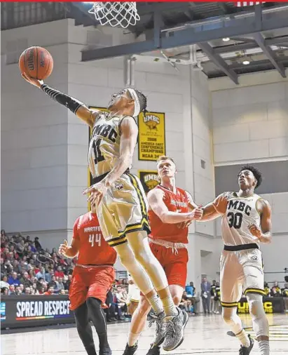  ?? KENNETH K. LAM/BALTIMORE SUN ?? UMBC guard K.J. Maura scores two of his team-high 18 points in the Retrievers’ victory over Hartford. Maura also led the team’s defense, which forced Hartford into 14 turnovers in the America East semifinal at the UMBC Event Center. UMBC improved to...