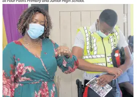  ??  ?? Rose-Marie Logan, principal at Four Paths Primary and Junior High join with Constable Richard Roye of the Four Paths Police Station to pray for peace at a remembranc­e service at the school for Nattalie Dawkins on Thursday.