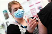  ?? ALASTAIR GRANT / AP ?? Pharmacy Technician Katrina Bonwick administer­s a dose of the AstraZenec­a COVID-19 vaccine Thursday in Luton, England.