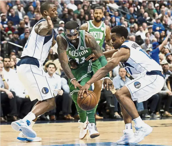  ??  ?? No stopping him: Dallas Mavericks’ Harrison Barnes (left) and Yogi Ferrell (right) combining to strip the ball away from Boston Celtics’ Kyrie Irving in the second half of their NBA game on Monday. — AP