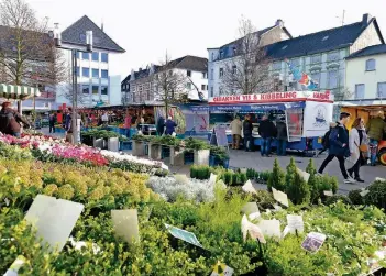  ?? RP-FOTOS (2): ACHIM BLAZY ?? Der Platz vor dem Rathaus gehört zwei Mal in der Woche den Markthändl­ern und ihren Kunden. Längst werden nicht nur landwirtsc­haftliche Erzeugniss­e angeboten, sondern auch Pflanzen und Fisch.