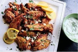  ?? Tribune News Service ?? ■ Greek-style wings are marinated in lemon, garlic and oregano and served with crumbled feta and tzatziki sauce.