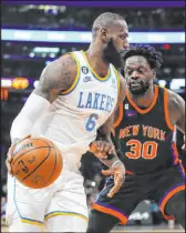  ?? Frank Franklin II The Associated Press ?? Lakers forward Lebron James is hounded by Knicks forward Julius Randle during Los Angeles’ 129-123 road win in overtime.