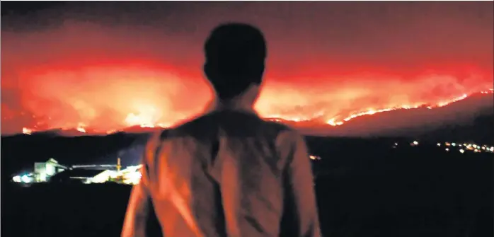  ?? PATRICIA DE MELO / AFP ?? Un hombre observa desde una carretera el gigantesco incendio que ayer acabó con la vida de decenas de personas en Anciao, Leiria (centro de Portugal).