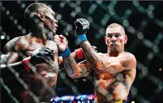  ?? (AP) ?? Brazil’s Alex Pereira (right), blocks a punch from Nigeria’s Israel Adesanya during the fifth round of a middleweig­ht title bout in the UFC 281 mixed martial arts event in New York. Pereira stopped Adesanya in the fifth round.