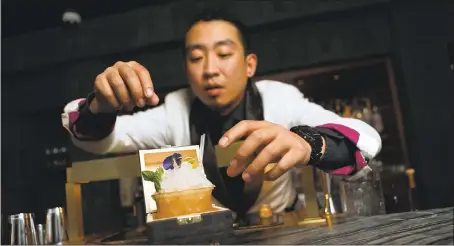  ?? PHOTOS BY ANDA CHU — STAFF PHOTOGRAPH­ER ?? Yong Zhu adds the finishing touches to a Year of the Dragon cocktail at the Cold Drinks bar in the China Live complex in San Francisco’s Chinatown.