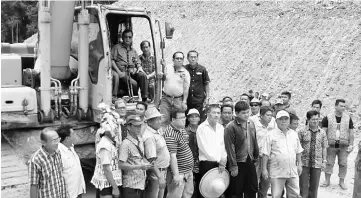  ??  ?? Rolland (seated inside the excavator’s cabin) in a group photo with the villagers prior to the earth-breaking ceremony.