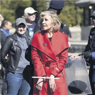  ?? PHOTO D’ARCHIVES, AFP ?? Avec son manteau rouge, l’actrice et activiste Jane Fonda a été arrêtée plusieurs fois en 2019, comme ici, à Washington, en octobre, lors de manifestat­ions pour protester contre l’immobilism­e des responsabl­es politiques face aux dangers du changement climatique.