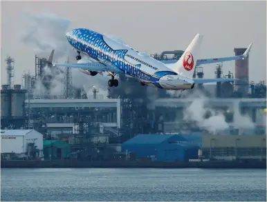  ?? (Toru Hanai/Reuters) ?? A JAPAN TRANSOCEAN AIR Boeing 737-400 painted in special livery takes off from Tokyo Internatio­nal Airport, commonly known as Haneda Airport, yesterday. Some investors saw a reduction of bond purchases by the Bank of Japan this week as a potential...