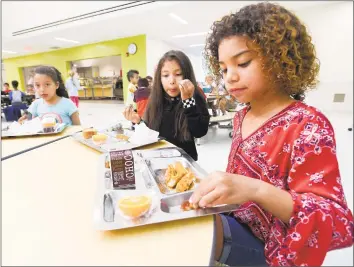  ?? Matthew Brown / Hearst Connecticu­t Media ?? Anna Marie Henry-Taska, a second grader at New Lebanon School enjoys her lunch. The school piloted metal trays this week, part of an effort by the Green Schools Committee to reduce waste during school lunch.