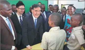  ?? PANG XINGLEI / XINHUA ?? Wang Yang, chairman of the National Committee of the Chinese People’s Political Consultati­ve Conference, speaks to students during a visit to the Mpila Middle School in Brazzavill­e, the Republic of Congo, on Tuesday.