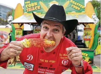  ?? Yi-Chin Lee / Houston Chronicle ?? Dominic Palmieri bites into Flamin’ Hot Cheetos Roasted Corn from the Corn Shack at the rodeo.