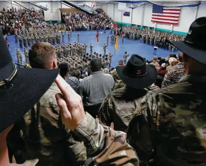  ?? Curtis Compton / Associated Press ?? Georgia National Guardsmen salute the colors during their departure ceremony in December. Deployers have many options to prepare their families financiall­y for their extended absence.