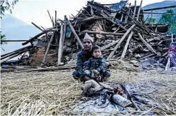  ?? ?? QUAKE SURVIVORS — Survivors of a recent earthquake sit in front of a damaged house in Chiuri village at Jajarkot district on November 5, 2023. At least 157 people were killed in isolated western districts of the Himalayan country when the 5.6-magnitude earthquake hit late November 3. (AFP)