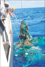  ?? AFP / Getty Images ?? This handout photo released last month by Ocean Cleanup shows Mega Expedition mothership Ocean Starr crew pulling a ghost net from the Pacific Ocean filled with litter. Researcher­s have engineered an enzyme that eats plastic and may eventually help...