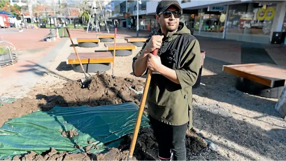  ?? TOM LEE/STUFF ?? Parekura Collins, from Te Kōpū Mānia o Kirikiriro­a Marae, helping prepare the hangi in Hamilton’s Garden Place.