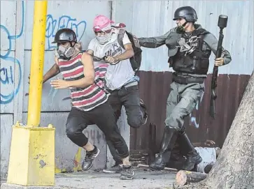  ?? Juan Barreto AFP/Getty Images ?? PROTESTERS clash with a member of the national guard during a demonstrat­ion in Caracas, Venezuela. President Nicolas Maduro declared all protests from Friday through Sunday to be illegal.