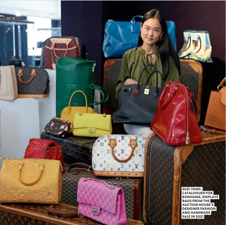  ?? ?? SUZI YANG, CATALOGUER FOR BONHAMS, DISPLAYS BAGS FROM THE AUCTION HOUSE’S DESIGNER FASHION AND HANDBAGS SALE IN 2021