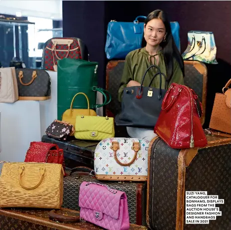  ?? ?? SUZI YANG, CATALOGUER FOR BONHAMS, DISPLAYS BAGS FROM THE AUCTION HOUSE’S DESIGNER FASHION AND HANDBAGS SALE IN 2021