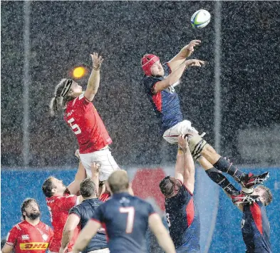  ??  ?? Canada’s Evan Olmstead, left, and Hong Kong's Fin Field challenge for the ball in rainy Marseille, France, on Friday during their last-chance qualifying match for the 2019 Rugby World Cup in Japan. The Langford-based Canadian men won 27-10.