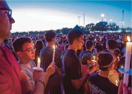  ?? EPA PIC ?? Hundreds of community members at a candleligh­t vigil to honour victims of a mass shooting at the Marjory Stoneman Douglas High School that left 17 dead. The lack of meaningful gun-control legislatio­n has frustrated millions of Americans.