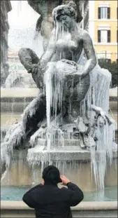  ?? MAX ROSSI / REUTERS ?? A man takes pictures in front of the frozen Naiadi fountain in downtown Rome on Wednesday.