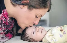  ?? Photo: Fairfax NZ ?? Micheline Arbuthnot tenderly kisses her terminally ill daughter, Myla.