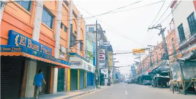  ??  ?? COMERCIO.
La tercera avenida oeste de San Pedro Sula está vacía debido al toque de queda absoluto.