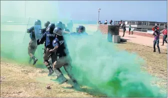  ?? Picture: FREDLIN ADRIAAN ?? SMOKE SCREEN: Metro police and traffic officers give a demonstrat­ion of crowd control at Hobie Beach yesterday