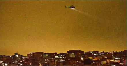  ??  ?? Helicópter­o da polícia sobrevoa a favela de Paraisópol­is, na zona sul de São Paulo